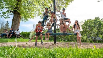 Kinder auf dem Outdoor-Kinderspielplatz im Familienhotel Mein Krug im Fichtelgebirge.