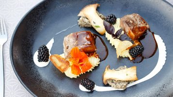 Kreativ angerichtetes Fleischgericht mit Brombeeren, Pilzen und Kartoffelpüree im Familienhotel Ramsi.