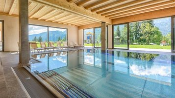 Lichtdurchfluteter Indoorpool mit traumhaftem Bergblick im Familienhotel Ramsi in Kärnten