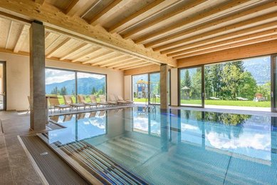 Lichtdurchfluteter Indoorpool mit traumhaftem Bergblick im Familienhotel Ramsi in Kärnten