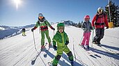 Eine Familie ist Skifahren auf der Piste vom Familienhotel Galtenberg Family & Wellness Resort in Tirol.