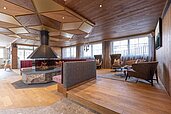 Große Lobby mit vielen Sitzmöglichkeiten und einem Kamin im Familienhotel Galtenberg Family & Wellness Resort in Tirol.