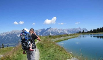 Vater mit Baby in der Kraxe beim Wandern in Deutschland.