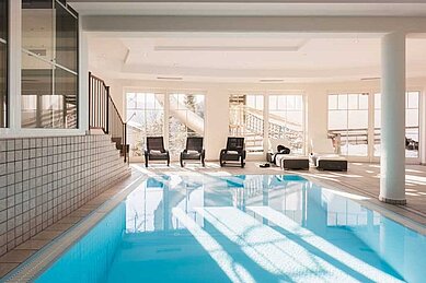 Schwimmbecken mit Liegen im Familienhotel Adler Familien- & Wohlfühlhotel in Tirol.