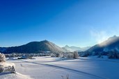 Winterpanorama mit Blick auf Nesselwang und die verschneiten Berge rund um das Familienhotel Bavaria. Alt-Text Bild 3: Sonnenau