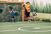 Zwei Jungs spielen Fußball auf dem Indoor Fußballplatz des Familienhotels Sonnenpark im Sauerland.