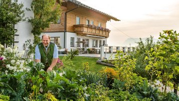Ein Mann in seinem Garten vor seinem Haus in der Region Altenmarkt 