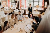 Eine Familie sitzt gemeinsam im Restaurant des Hotel Sonngastein im Salzburger Land am gedeckten Tisch.