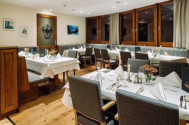 Gemütliches Restaurant mit gedeckten Tischen im Adler Familien- & Wohlfühlhotel in Tirol.