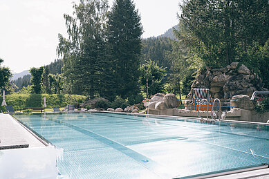 Außen-Pool mit Sonnenliegen im Familienhotel Kirchheimerhof in Kärnten.
