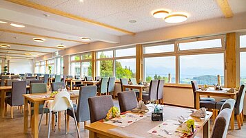 Restaurant mit Panoramafenstern und Kinderhochstühlen im Familienhotel Familien Resort Petschnighof in Kärnten.