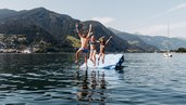 Familie springt gemeinsam in den See am Badeplatz im Familienhotel Amiamo im Salzburger Land.