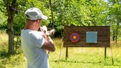 Ein Mann beim Bogenschießen auf dem Gelände vom Familienhotel Friedrichshof.