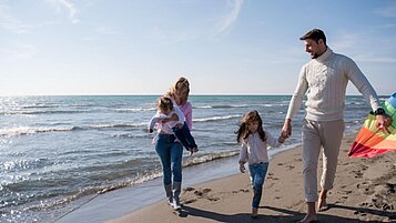 Eine Familie genißt die Zeit am Strand des Familienhotels strandkind an der Ostsee.