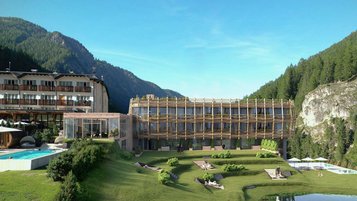 Das Familotel Bella Vista in Südtirol in den Bergen mit Pool, Liegewiese und modernem Holzgebäude vor bewaldeter Alpenlandschaft.