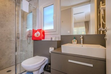 Modern ausgestattetes Badezimmer im Tiny House des Familienhotels Ramsi mit Dusche, WC und großem Spiegel