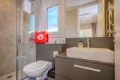 Modern ausgestattetes Badezimmer im Tiny House des Familienhotels Ramsi mit Dusche, WC und großem Spiegel