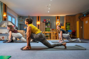 Eltern können im Familienhotel Mein Krug Yogakurse besuchen und sich Entspannung und Bewegung gönnen.