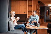 Eltern entspannen bei einer Tasse Kaffee in der Lounge des Familienhotels Family Home Alpenhof