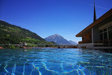 Infinity Pool mit Ausblick auf die Berge im Kinderhotel Stefan in Pitztal.