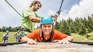 Junge beim Klettern im Familienurlaub im Salzburger Land.