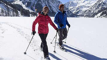 Zu Fuß geht es immer noch am Besten: ein Paar beim Wandern am Berg in Tirol im Winter.