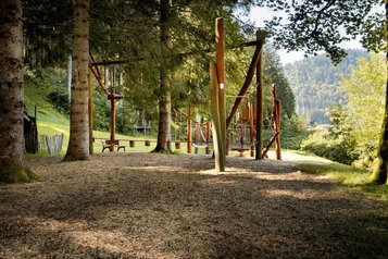 Seil- und Balancier-Parcours im schattigen Waldspielplatz des Familienhotels Krone im Allgäu.