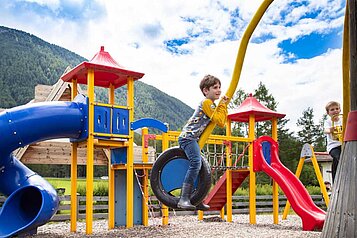 Großer Outdoor Spielplatz mit Rutschen im Familienhotel Lärchenhof in Tirol