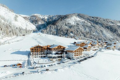 Luftaufnahme im Winter des Familienhotels Almfamilyhotel Scherer. 