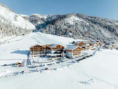 Luftaufnahme im Winter des Familienhotels Almfamilyhotel Scherer. 