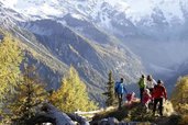 Familie wandert durch die herbstliche Berglandschaft in Südtirol.