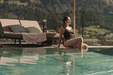 Entspannung im Panorama Infinity Pool des Familienhotel Mia Alpina in Tirol mit Blick auf die Tiroler Bergwelt.