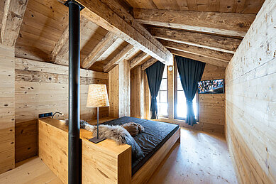 Moderner und großzügiger Schlafbereich für Eltern im Mons Silva Private Luxury Chalet in Südtirol. Die Chalets wurden aus traditioneller Holzbauweise gebaut.