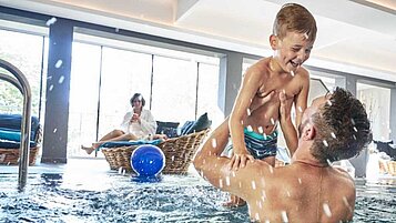 Die ganze Familie im Indoor-Schwimmbad im Familienhotel Amiamo im Salzburger Land.