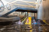 Drei Kinder rutschen fröhlich die bunte Trio Slide Rutsche im Alpenhotel Kindl im Sutbaital hinunter