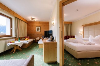 Gemütlich eingerichtetes Familienzimmer mit Doppelbett im Adler Familien- & Wohlfühlhotel in Tirol.
