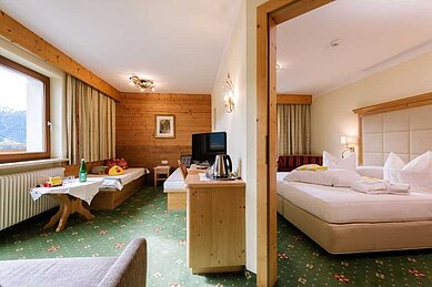 Gemütlich eingerichtetes Familienzimmer mit Doppelbett im Adler Familien- & Wohlfühlhotel in Tirol.
