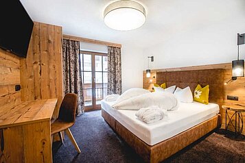 Geräumiges Elternschlafzimmer der Familiensuite "Alpina" des Familienhotels Alpenhotel Kindl in Tirol.