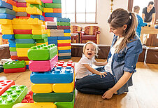 Mutter spielt mit ihrer kleiner Tochter in der Legoecke im Familienhotel Kaiserhof an der Zugspitze.