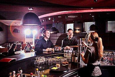 Cocktailbar mit Barkeeperin im Familienhotel Aigo welcome family in Oberösterreich