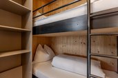 Gemütliches Kinderzimmer mit Stockbett im Familienhotel Almfamilyhotel Scherer, gestaltet in warmem Holzdesign.
