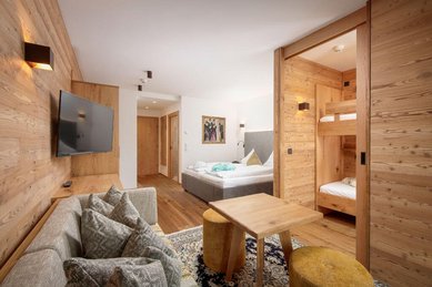 Gemütlicher Rückzugsort für die ganze Familie! Die stilvolle Familiensuite im Landgut Furtherwirt mit Holzdesign, Kuschelcouch und separatem Kinderbereich sorgt für Wohlfühlatmosphäre