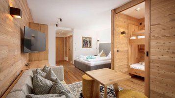 Gemütlicher Rückzugsort für die ganze Familie! Die stilvolle Familiensuite im Landgut Furtherwirt mit Holzdesign, Kuschelcouch und separatem Kinderbereich sorgt für Wohlfühlatmosphäre