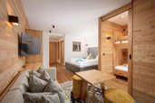 Gemütlicher Rückzugsort für die ganze Familie! Die stilvolle Familiensuite im Landgut Furtherwirt mit Holzdesign, Kuschelcouch und separatem Kinderbereich sorgt für Wohlfühlatmosphäre