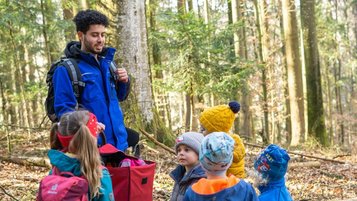 Einige Kinder und ein Kinderbetreuer im Outdoorclub im Wald im Landhaus zur Ohe im Bayerischen Wald. 