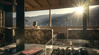 Ruhebereich im Familienhotel Mia Alpina in Tirol mit Liegefläche, großen Fenstern und Bergpanorama bei Sonnenlicht.