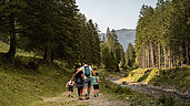Familie beim Wanderung durch Wald und Wiesen im Familienurlaub in Liechtenstein.