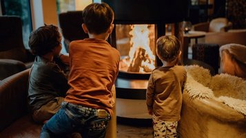 Gemütliche Familienzeit am Kamin im Familienhotel Mia Alpina in Tirol.