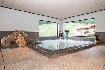 Kinderbecken mit bunten Tierfiguren und Wasserspielen im Familienhotel Oberkarteis.