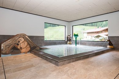 Kinderbecken mit bunten Tierfiguren und Wasserspielen im Familienhotel Oberkarteis.
